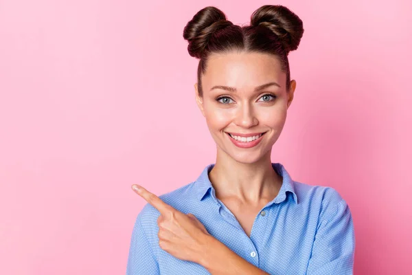 Kuva muotokuva hymyilevä tyttö top-solmu kampauksen osoittaa sormella tyhjä tila eristetty pastelli vaaleanpunainen väri tausta — kuvapankkivalokuva