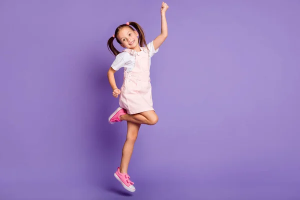Pełny rozmiar zdjęcie funky szczęśliwy ładna dziewczyna podnieść pięść skakać powietrze nosić różowy sukienka izolowane na fioletowy kolor tła — Zdjęcie stockowe