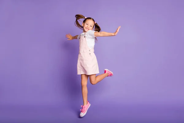 Comprimento total de despreocupado feliz menina pequena usar vestido rosa levantar as mãos bom humor isolado no fundo cor violeta — Fotografia de Stock