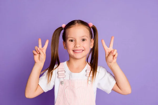 Foto de colegial doce feliz fazer v-sinal desgaste branco t-shirt vestido rosa isolado no fundo cor violeta — Fotografia de Stock