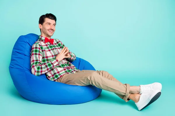 Foto di uomo sedersi beanbag tenere le dita cercare spazio vuoto indossare camicia a quadri arco isolato colore blu sfondo — Foto Stock