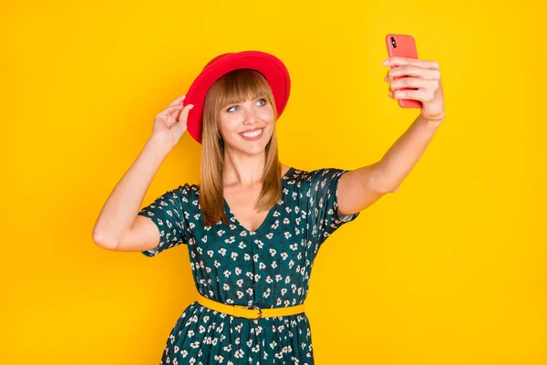 Портрет чарівної веселої дівчини, що приймає селфі позує зворушливий капелюх, розважається ізольовано на яскраво-жовтому кольоровому фоні — стокове фото