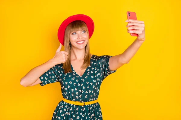 Портрет чарівної веселої дівчини, яка робить селфі, показуючи рекламу мініатюр, погоджуються ізольовані на яскраво-жовтому кольоровому фоні — стокове фото