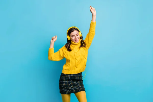 Foto de adorable linda mujer joven vestida con auriculares de jersey amarillo ojos cerrados bailando aislado fondo de color azul —  Fotos de Stock