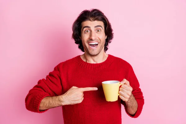 Portrait d'un beau gars joyeux qui boit en démontrant une boisson isolée sur fond rose pastel — Photo