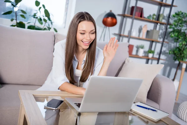 Foto di giovane donna allegra sorridente positiva che mostra le mani saluti parlando con gli amici online in un divano portatile seduto a casa — Foto Stock