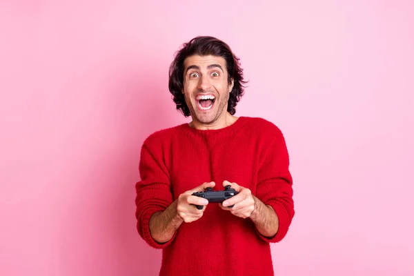 Photo portrait of excited screaming man holding gamepad in two hands isolated on pastel pink colored background — Stock Photo, Image