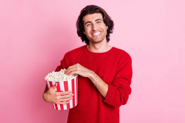 Foto retrato de sorrindo feliz morena masculina mantendo caixa com pipoca isolada no fundo cor-de-rosa pastel — Fotografia de Stock