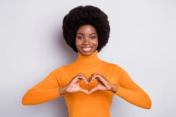 Foto de mulher afro-americana atraente fazer dedos coração figura bom humor isolado no fundo de cor cinza — Fotografia de Stock