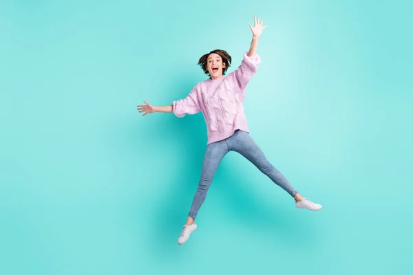 Lunghezza completa foto di divertente dolce giovane donna indossare maglione viola braccio ondulante salto isolato colore turchese sfondo — Foto Stock