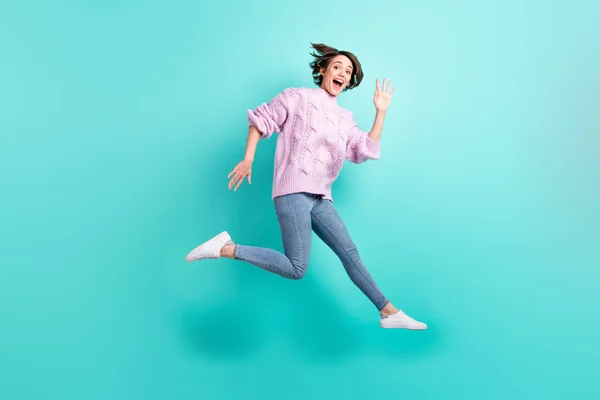 Foto de longitud completa de brillante excitado joven dama vestido púrpura jersey saltando brazo de agitación fondo de color verde azulado aislado —  Fotos de Stock