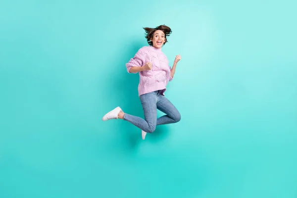 Foto de larga duración de la suerte encantadora joven dama vestida púrpura jersey saltando puños de gran altura aislado color verde azulado fondo — Foto de Stock