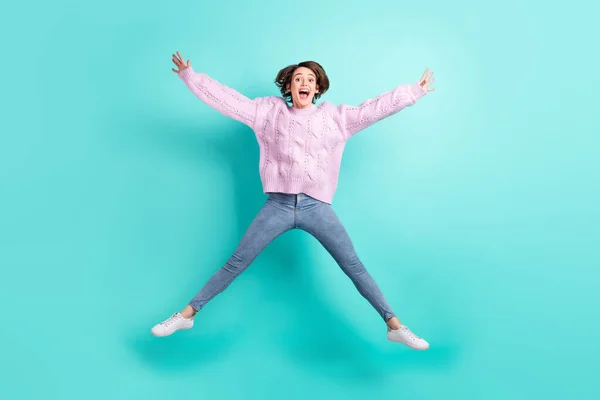 Volledige lengte foto van grappige charmante jonge vrouw dragen violet trui springen als ster geïsoleerde turquoise kleur achtergrond — Stockfoto