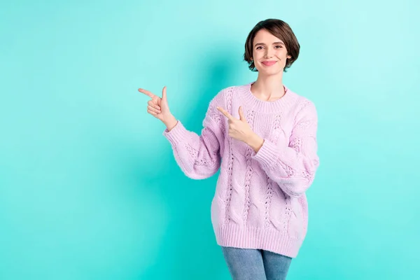 Foto de doce bonito jovem mulher desgaste violeta suéter apontando dois dedos vazio espaço isolado turquesa cor fundo — Fotografia de Stock