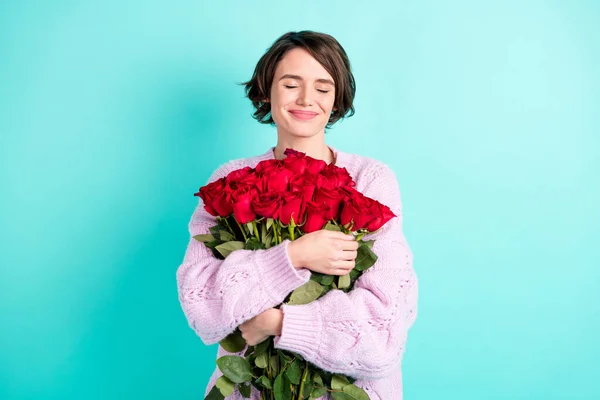 Φωτογραφία από λαμπερό ονειρική γυναίκα φορούν βιολετί πουλόβερ αγκαλιάζει τεράστιο μπουκέτο τριαντάφυλλα κλειστά μάτια απομονωμένο τυρκουάζ φόντο χρώμα — Φωτογραφία Αρχείου