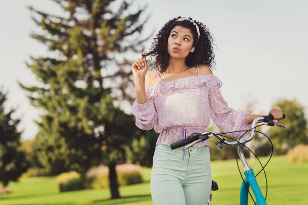 Retrato de encantadora piel oscura positiva señora mira interesado dedo lejano jugar con el pelo tiempo libre vacaciones al aire libre —  Fotos de Stock