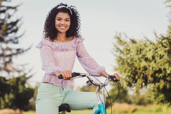 밝고 환한 피부를 가진 매력적 인 사람 이 자전거에 앉아 있는 모습어여쁜 미소 주말 카메라를 타고 야외에 나가는 모습 — 스톡 사진