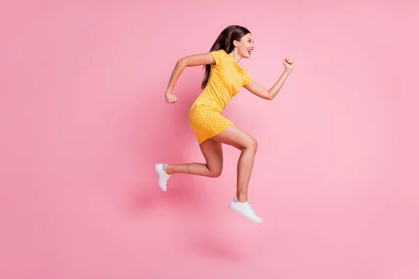 フルサイズプロファイル側の写真の魅力的な明るいトレンディーな若い女性ジャンプアップ実行コピースペース隔離されたピンク色の背景 — ストック写真