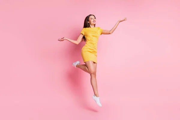 Pełne ciało zdjęcie marzycielskiej młodej kobiety nosić krótką spódnicę żółty kropkowana sukienka skakać powietrze wygląd copyspace izolowane na różowy kolor tła — Zdjęcie stockowe
