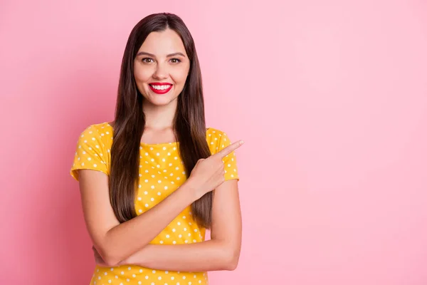 Foto de atractiva mujer joven de pie dedo dedo vacío espacio agradable sonrisa aislada sobre fondo de color rosa —  Fotos de Stock