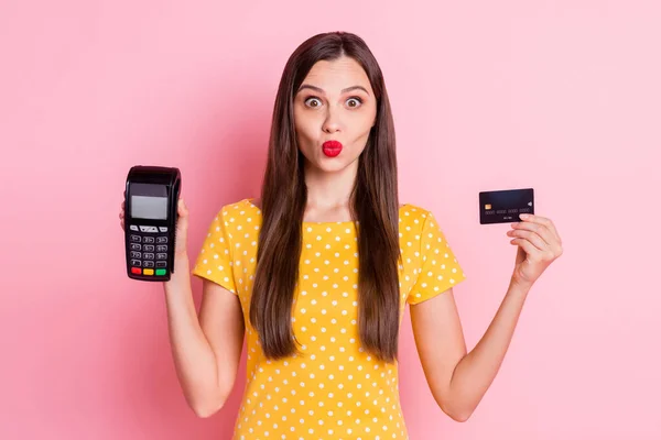 Foto av brun hår söt kvinna bära gul prickig t-shirt hålla trådlös terminal kreditkort isolerad på rosa färg bakgrund — Stockfoto
