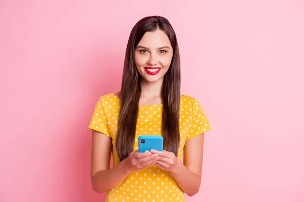 Foto van aantrekkelijke jonge vrouw houden smartphone goed humeur glimlach geïsoleerd op pastel roze kleur achtergrond — Stockfoto