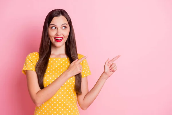 Foto de atractiva joven mujer usar amarillo punteado punto camiseta mirada espacio vacío aislado sobre fondo de color rosa pastel —  Fotos de Stock