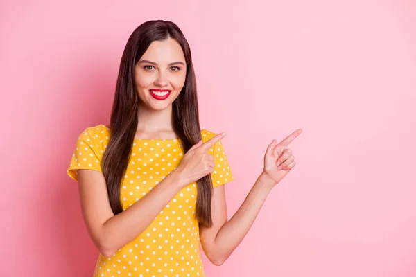 年轻女子穿着黄色圆点T恤衫的照片空空荡荡的空指广告孤立在粉红的背景上 — 图库照片