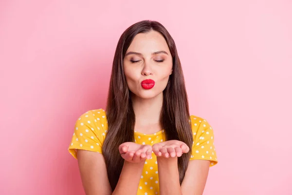 Foto de mujer joven atractiva coqueta enviar manos beso de aire que cerró los ojos aislados sobre fondo de color rosa pastel — Foto de Stock