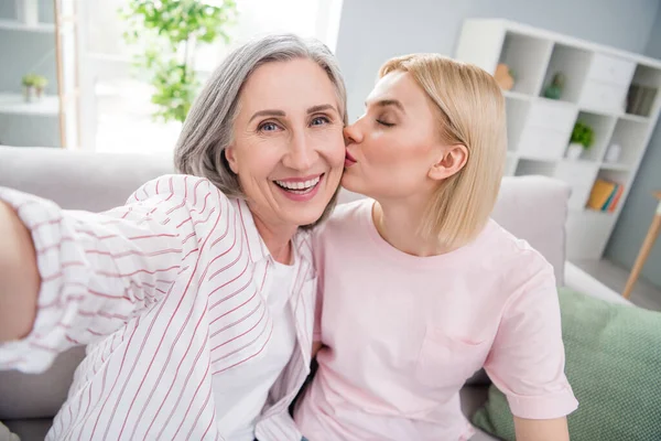 Фото счастливой веселой мамы и дочери сделать селфи улыбка поцелуй щека родитель в помещении дома — стоковое фото