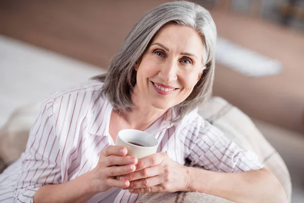 Foto de positiva bastante agradable anciana sostener taza de café sonrisa beber buen humor en el interior de la casa de casa — Foto de Stock