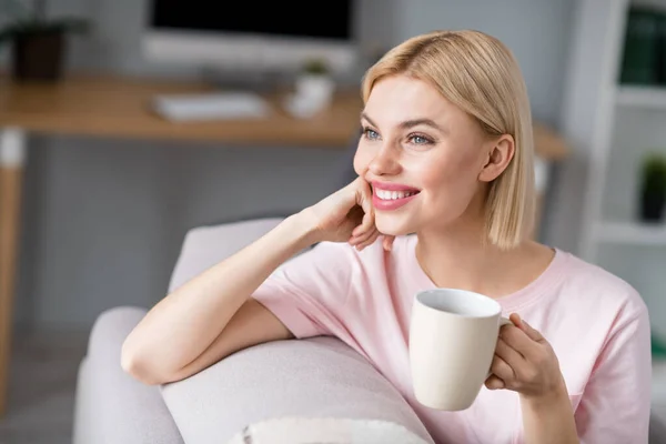 Foto van dromerig aantrekkelijk jong blond vrouw kijk weg te houden mok glimlach goed humeur binnen huis — Stockfoto