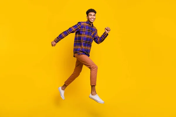 フル長さボディサイズサイドプロフィール写真の若い男不注意なジャンプ実行中の高速絶縁鮮やかな黄色の背景 — ストック写真