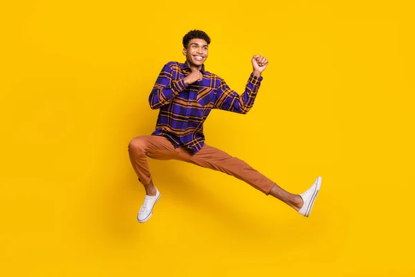 Longitud completa tamaño del cuerpo foto de un hombre joven descuidado saltando juguetona lucha en el entrenamiento aislado vibrante color amarillo fondo —  Fotos de Stock