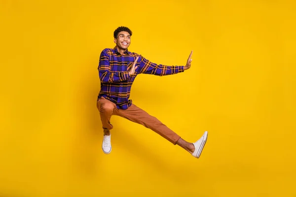 Full längd foto av ung afro man glad leende hoppa upp visa händer ingen stopp tecken isolerad över gul färg bakgrund — Stockfoto