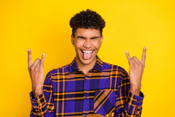 Foto porträtt av ung man ler visar heavy metal gest tunga galen isolerad ljus gul färg bakgrund — Stockfoto