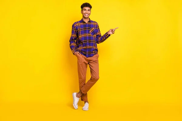 Foto em tamanho completo do jovem feliz sorriso positivo indicar dedo espaço vazio anúncio promo aconselhar isolado sobre fundo de cor amarela — Fotografia de Stock