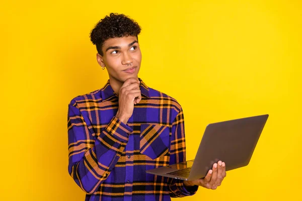 Foto ritratto di giovane uomo che lavora sul computer pensando cercando spazio vuoto isolato vibrante colore giallo sfondo — Foto Stock