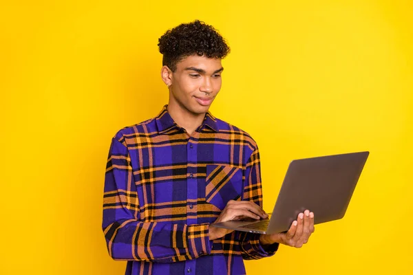 Fotografie mladého afro man vzhled Procházet notebook typ chatu e-mailový programátor izolované přes žlutou barvu pozadí — Stock fotografie