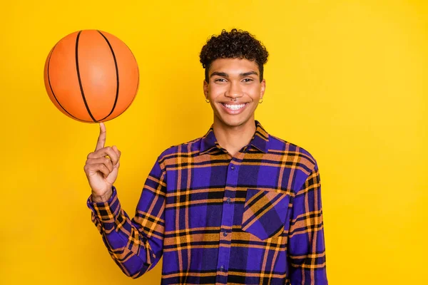 Foto retrato de jovem brincando com bola sorrindo em camisa xadrez isolado vibrante cor amarela fundo — Fotografia de Stock