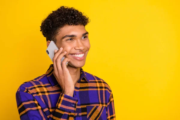 Profile portrait of cheerful dark skin guy speak phone have good mood isolated on yellow color background — Stock Photo, Image