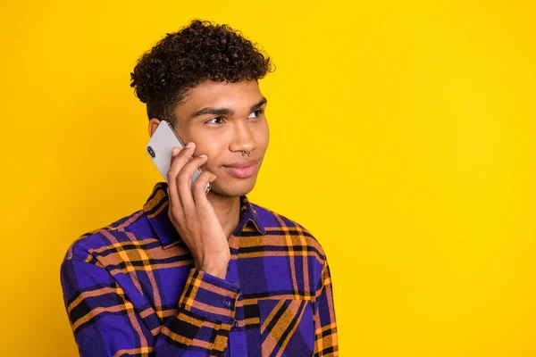 Foto van jonge afro man spreken luisteren oproep praten mobiele telefoon kijken lege ruimte geïsoleerd over gele kleur achtergrond — Stockfoto