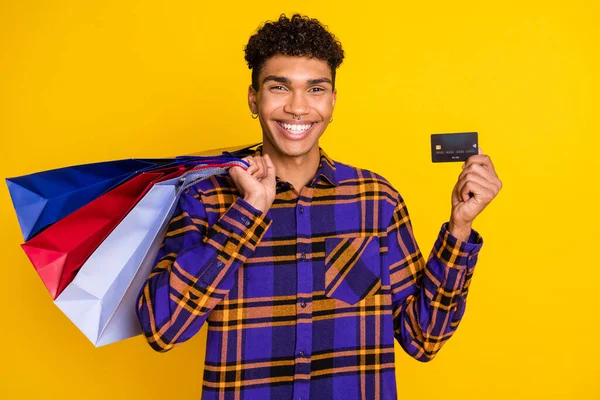 Foto retrato de cara mostrando v-sinal mantendo pechinchas mostrando cartão de banco isolado no fundo cor amarela vibrante — Fotografia de Stock