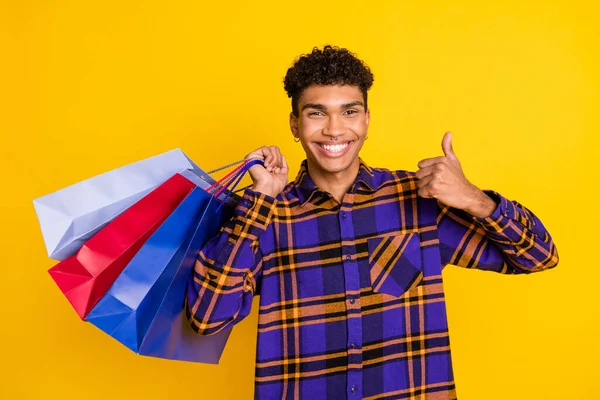 Portrait photo d'un beau mec souriant montrant le pouce levé gardant le sac après avoir fait ses courses isolé sur fond de couleur jaune vif — Photo