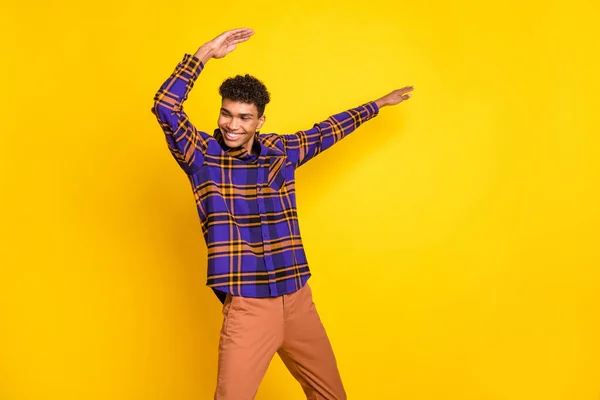 Foto de joven emocionado hombre feliz sonrisa positiva divertirse disfrutar de la danza mirada espacio vacío aislado sobre fondo de color amarillo — Foto de Stock