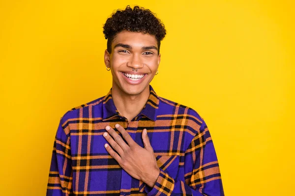 Foto ritratto di bel ragazzo ridere tenendo mano sul petto isolato su sfondo di colore giallo brillante — Foto Stock