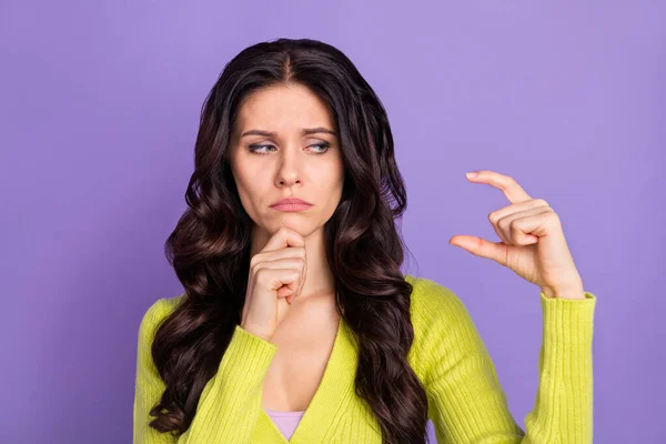 Фотографічний портрет сумної нещасної брюнетки, що показує пальці мало розміру ізольовані на пастельному фіолетовому кольоровому фоні — стокове фото