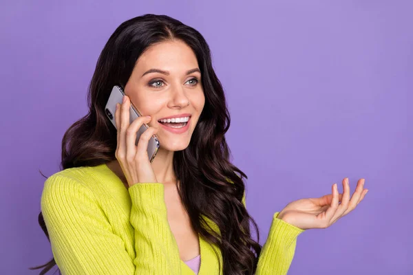 Фотопортрет брюнетки, говорящей по мобильному телефону, улыбающейся изолированно на пастельно-фиолетовом фоне — стоковое фото