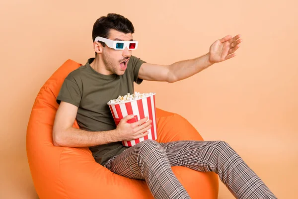 Foto retrato de homem assistindo tv comer milho pop surpreso mal-entendido animado isolado no fundo cor bege pastel — Fotografia de Stock