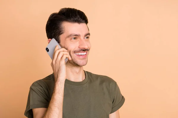 Photo portrait of man smiling cheerful talking on cellphone looking blank space isolated on pastel beige color background — 图库照片